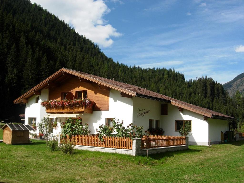 a white house with flowers in a field at Bergfeuerhof in Kaunertal