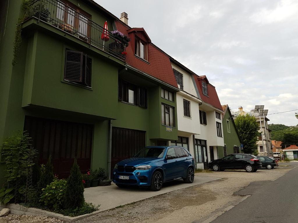 un coche azul estacionado frente a un edificio en Guest House Pansion 10, en Cetinje