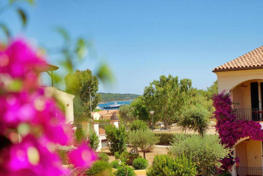 een uitzicht op een huis met bloemen op de voorgrond bij residence ulisse in Santa Teresa Gallura