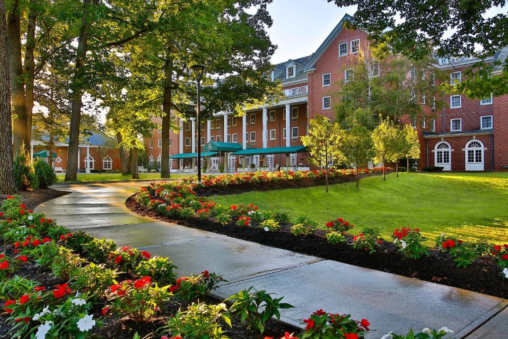 a building with a garden of flowers in front of a building at Gideon Putnam Resort & Spa in Saratoga Springs