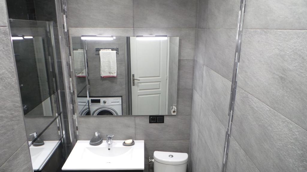 a bathroom with a sink and a mirror and a toilet at Catalans in Marseille