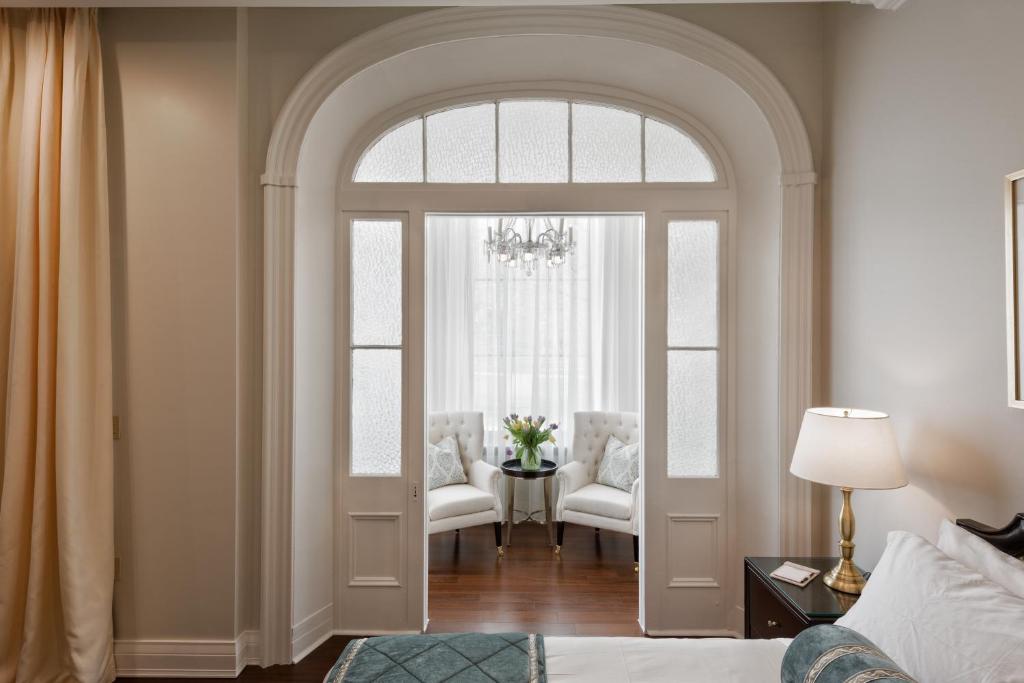 a room with an arched doorway with a bed and chairs at Sydney Boutique Inn & Suites in Charlottetown