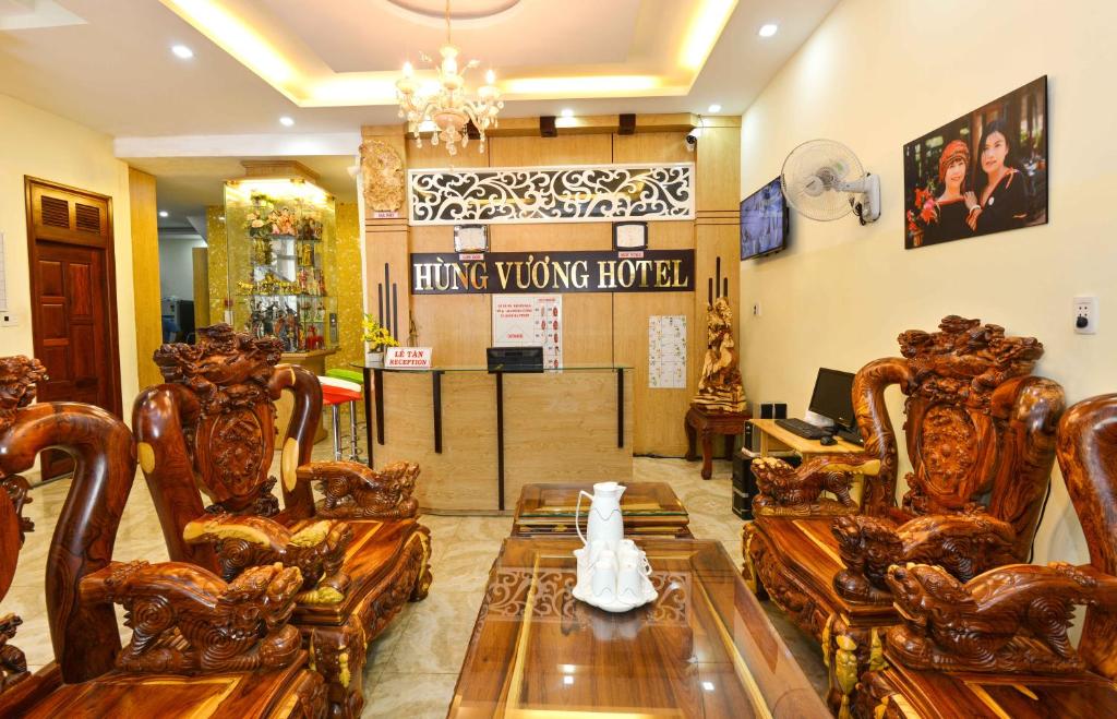 Hung Vuong Hotel في بون ما توت: غرفة معيشة مع كراسي خشبية وطاولة