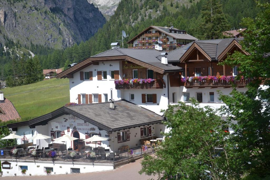 a large building with flowers on the balconies of it at Hotel Scoiattolo in Selva di Val Gardena