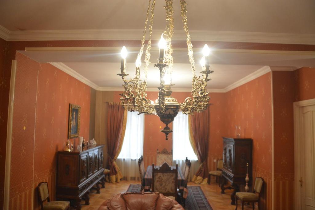 a living room with a chandelier and a room with chairs at Hotel Renesans in Tbilisi City