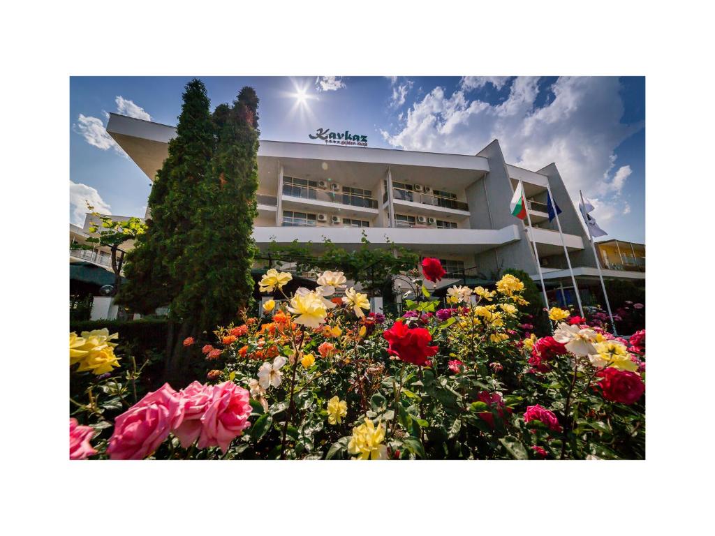 a building with a garden of flowers in front of it at Hotel Golden Dune in Sunny Beach