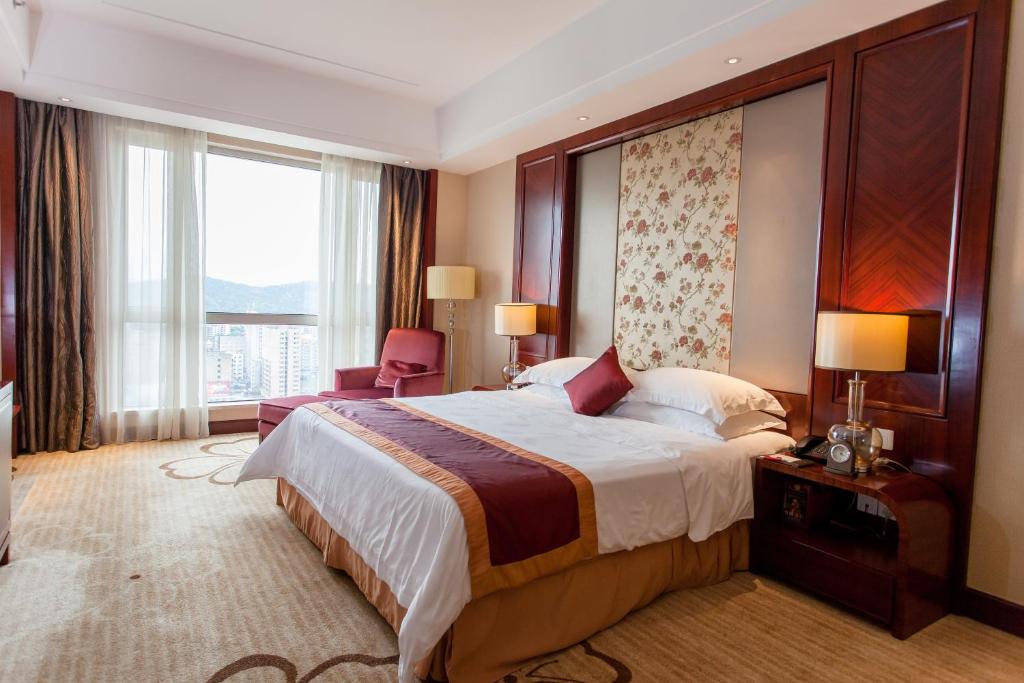 una camera d'albergo con un letto e una grande finestra di Ramada Plaza Shaoguan City Centre a Shaoguan