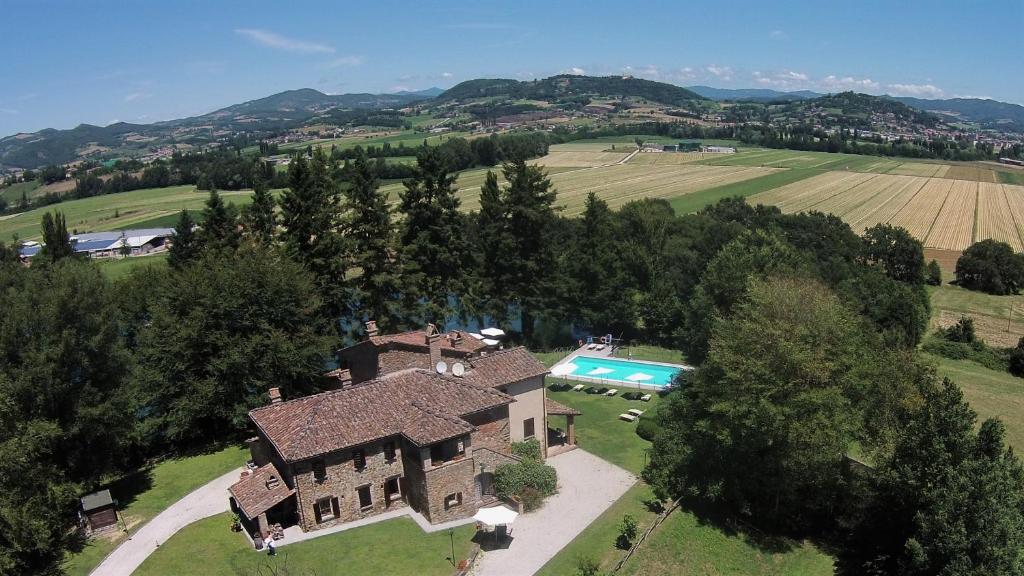 eine Luftansicht eines Hauses mit Pool in der Unterkunft Agriturismo Sant'illuminato in Calzolaro