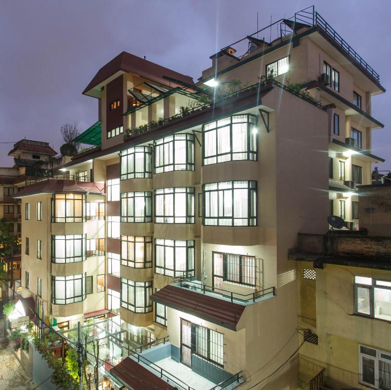 - un grand bâtiment avec des fenêtres et des balcons la nuit dans l'établissement Fuji Hotel, à Katmandou