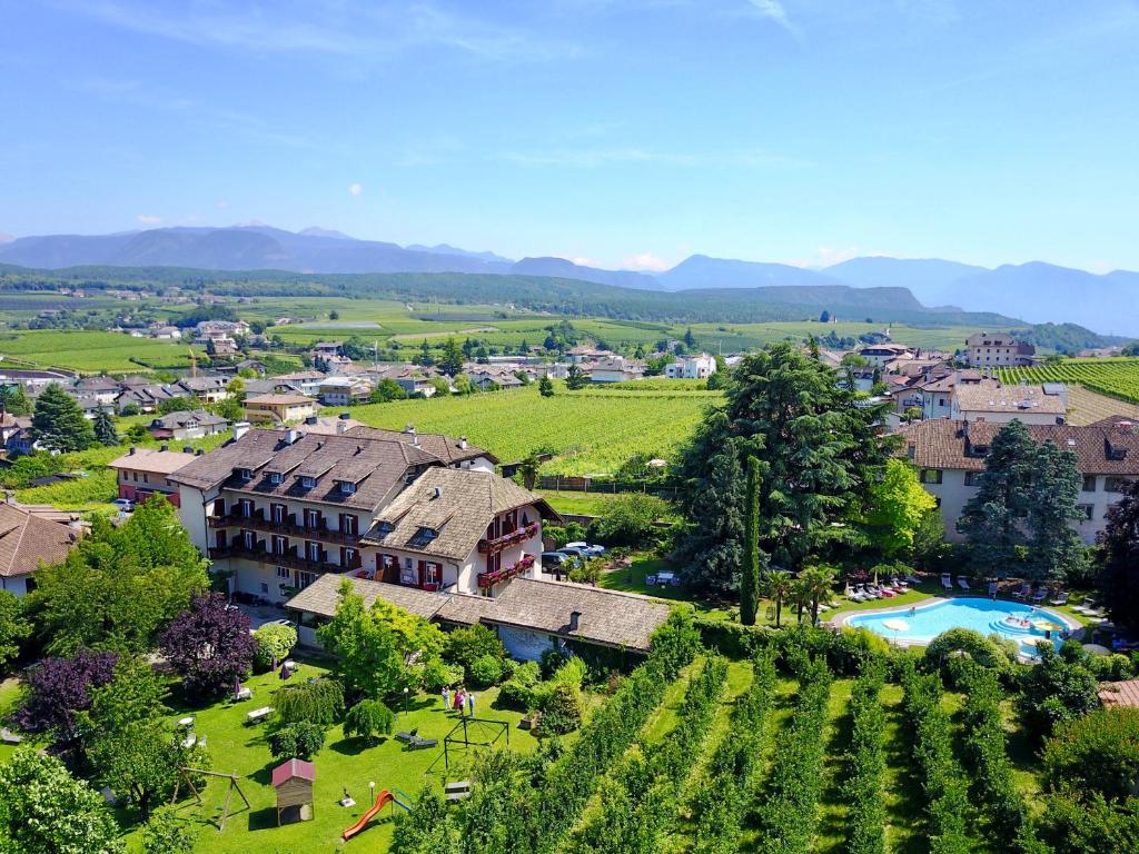 an aerial view of a village with a resort and a vineyard at Angerburg Blumenhotel in Appiano sulla Strada del Vino
