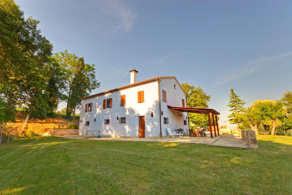 uma grande casa branca com um jardim relvado em Agriturismo Azzurro em Osimo