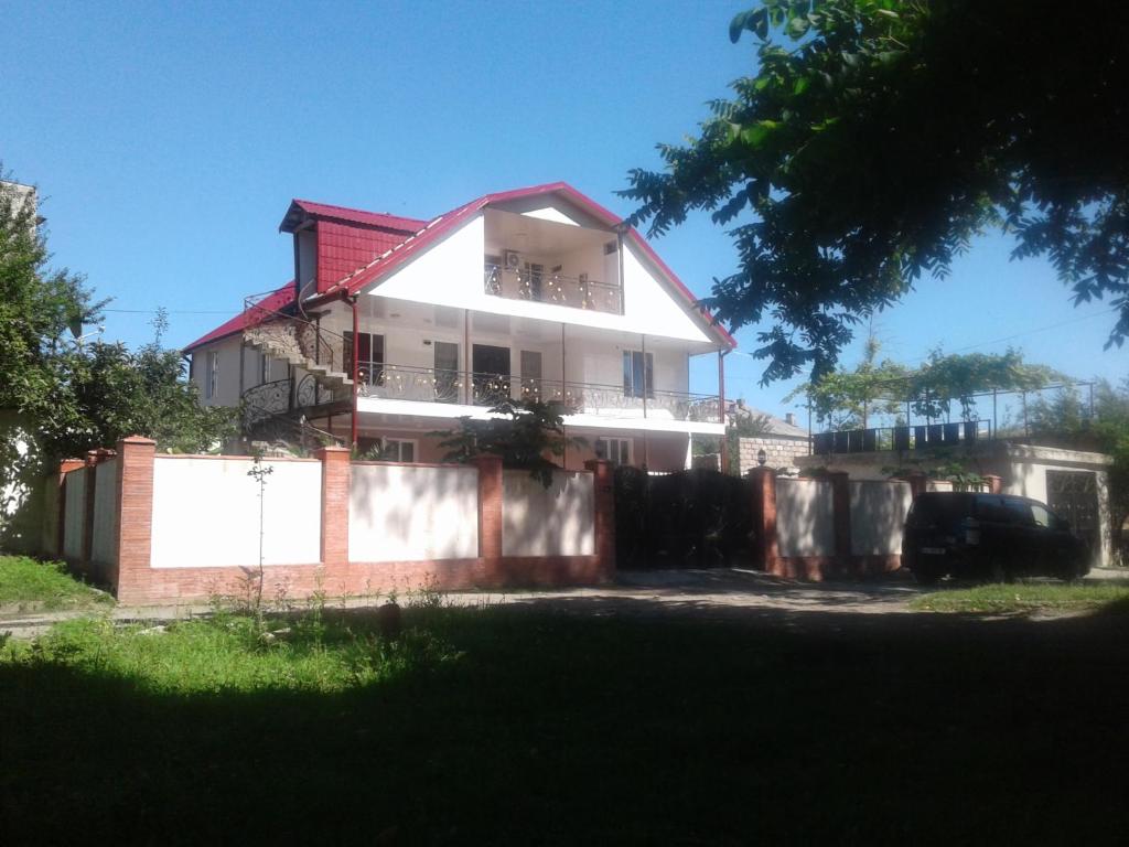 una casa bianca con una recinzione di fronte di Irina a Tskhaltubo