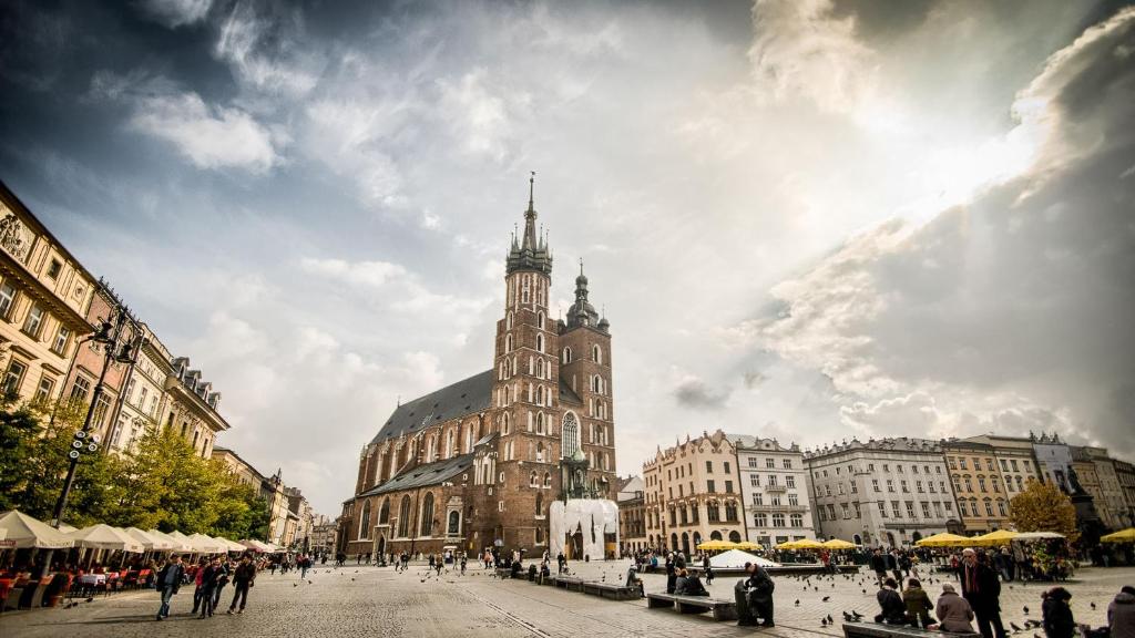 a large building with a clock tower in a city at LION apartments - Your own apartment in Cracow in Krakow