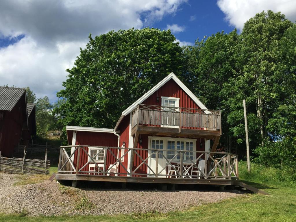 une maison rouge avec un balcon au-dessus dans l'établissement Vimmerby Lilla utsikten, à Tuna