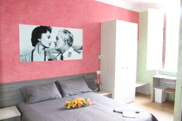 un dormitorio con un cartel de una pareja besándose en B&B Central Palace King Of Rome, en Roma