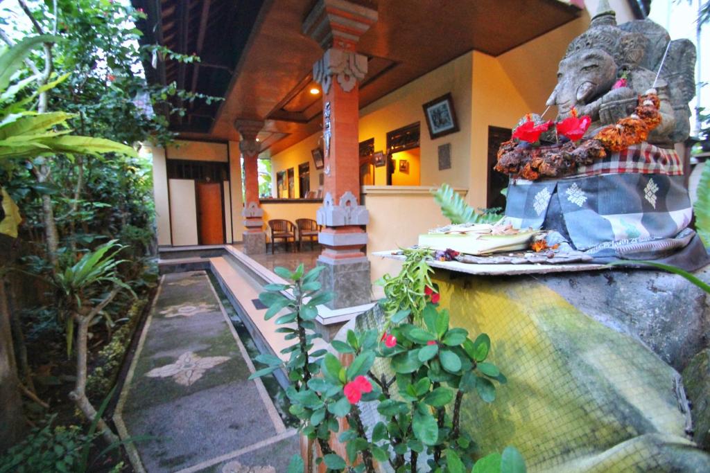 a building with a statue and a table with food on it at Suwar Bungalows in Ubud