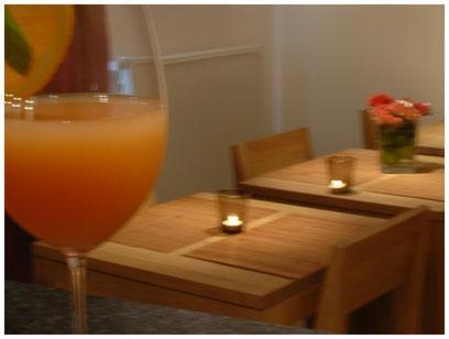 a glass of orange juice sitting on a wooden table at Hotel South Charleroi Airport in Charleroi