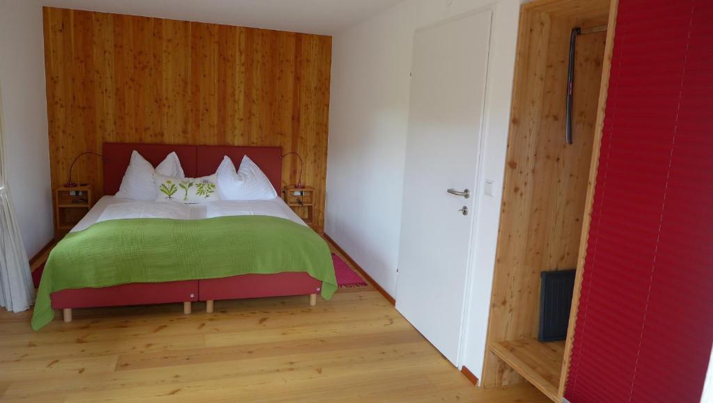 ein Schlafzimmer mit einem großen Bett und einer grünen Decke in der Unterkunft Gasthof Schallerwirt in Krakauebene