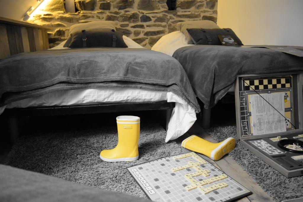 サン・ケ・ポルトリユーにあるMaison A Babord Plageの黄色いゴムのブーツが備わるベッド2台付きの部屋