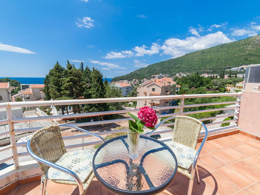 a table with a vase of flowers on a balcony at Apartments NICE in Petrovac na Moru