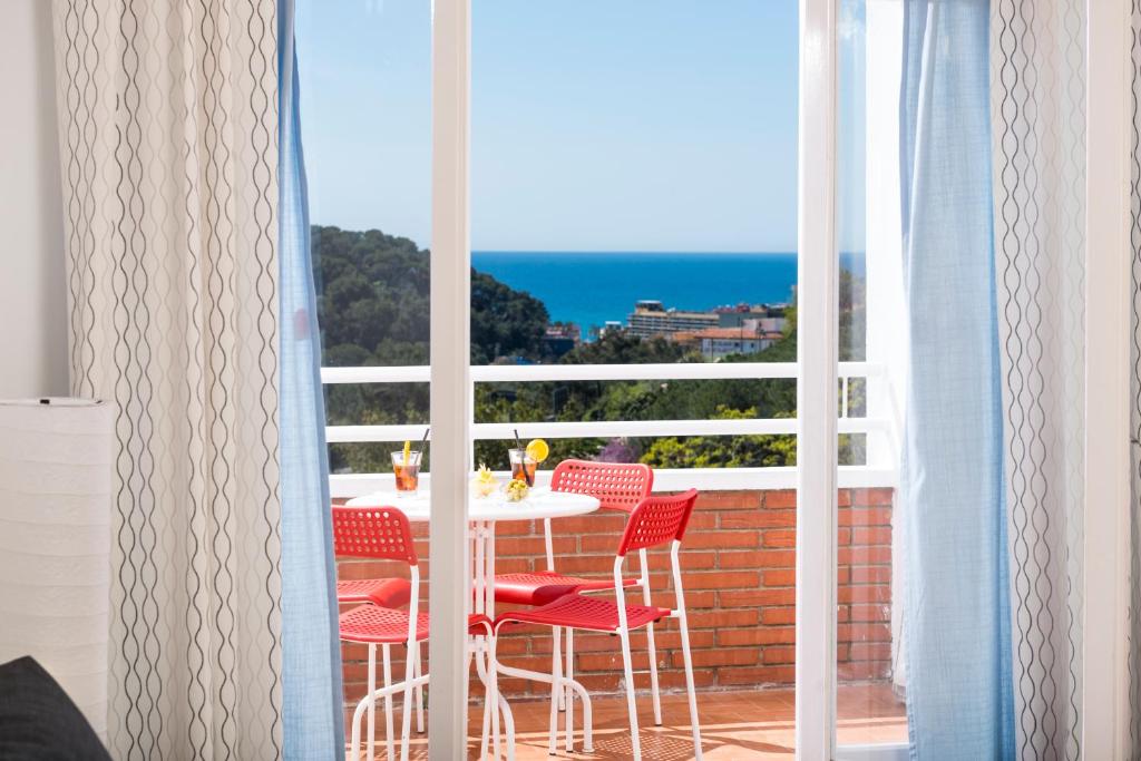 a table and chairs on a balcony with a view of the ocean at Apartaments Els Llorers in Lloret de Mar