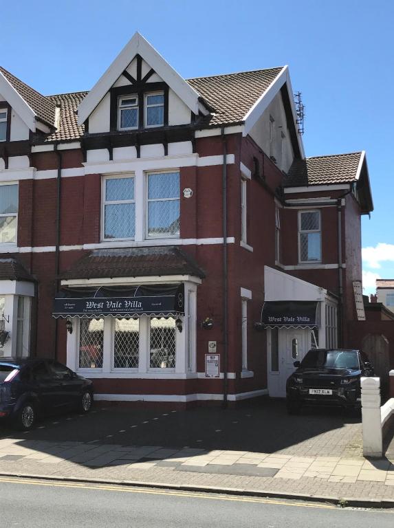 a red brick building with a sign for a shoe shop at West Vale Villa in Blackpool