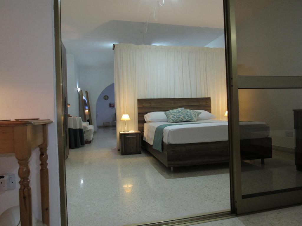 a bedroom with a bed and a mirror at Central Studio Apartment in Santa Venera