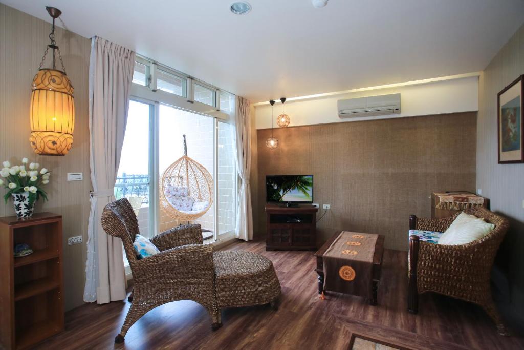 a living room with wicker chairs and a television at Yilan Ya Lu Homestay in Datong
