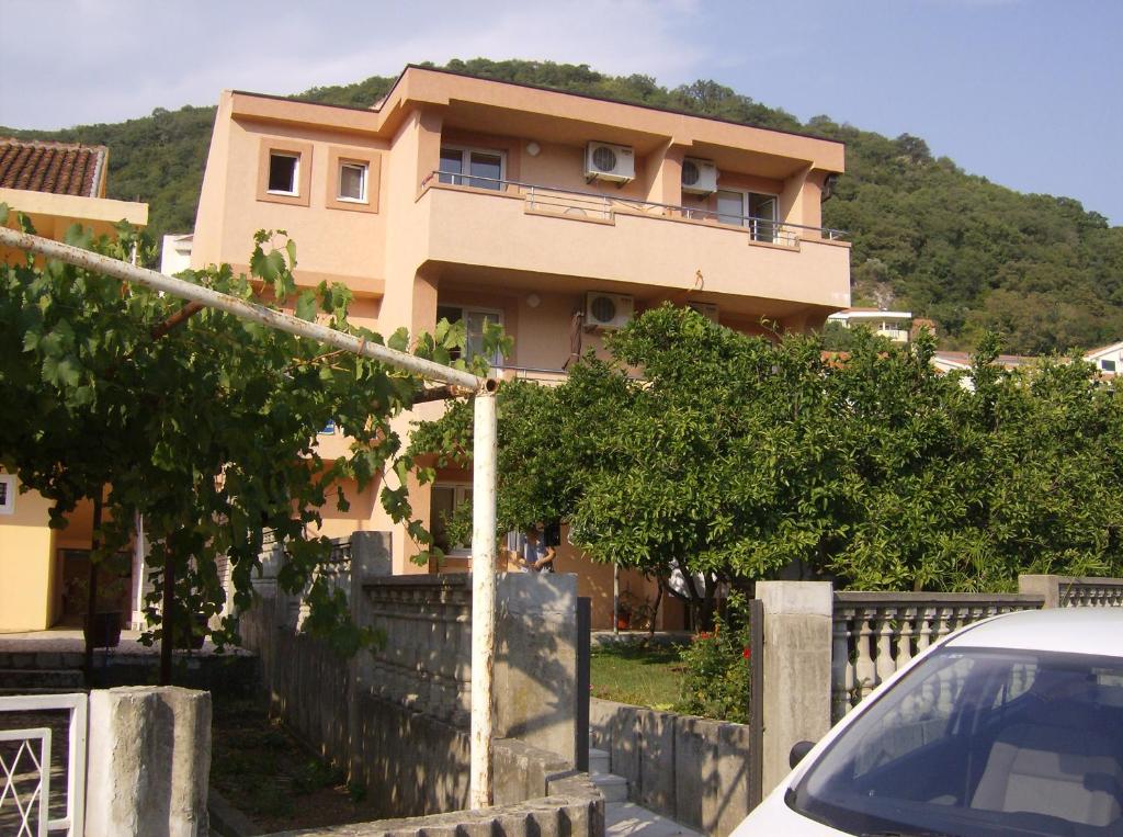 a house with a car parked in front of it at Guesthouse Lautasevic in Petrovac na Moru