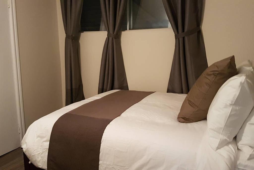 a bed with brown and white sheets and pillows at 2-Bedroom Apartment Sweet #5 by Amazing Property Rentals in Gatineau