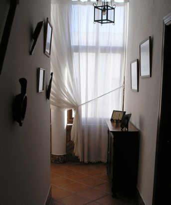 a hallway with a white curtain and a window at El Perro de Paterna in Paterna de Rivera