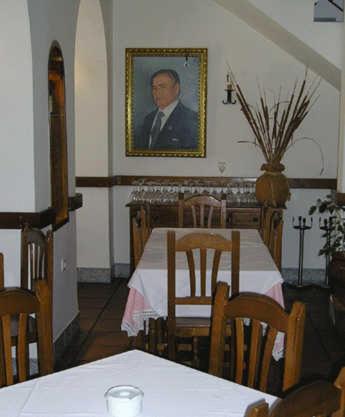 a dining room with a table and a picture of a man at El Perro de Paterna in Paterna de Rivera