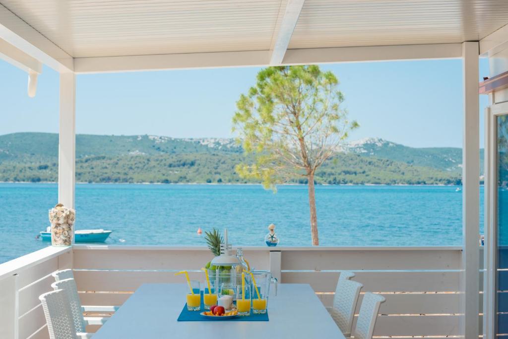 una mesa en un porche con vistas al agua en Mobile home Laguna en Sveti Petar