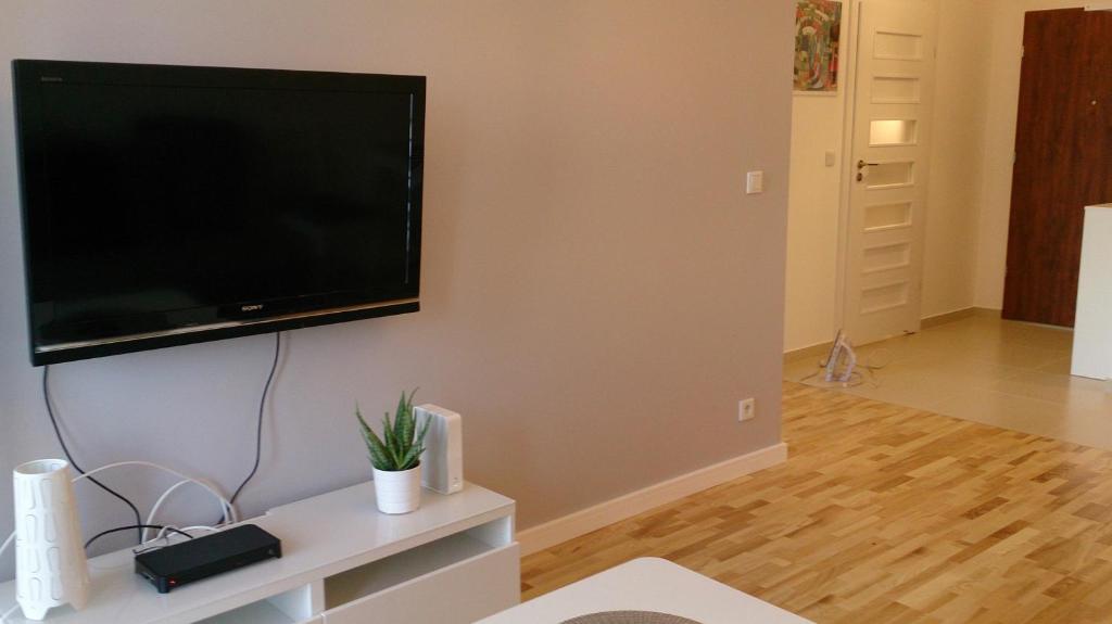 a living room with a flat screen tv on a wall at 1 Bedroom Francuska Park Apartment in Katowice