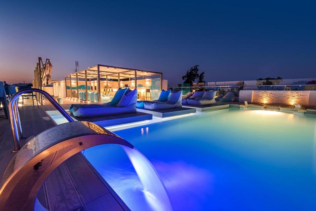 a swimming pool with blue pillows and couches on a building at Maritina Hotel in Kos Town