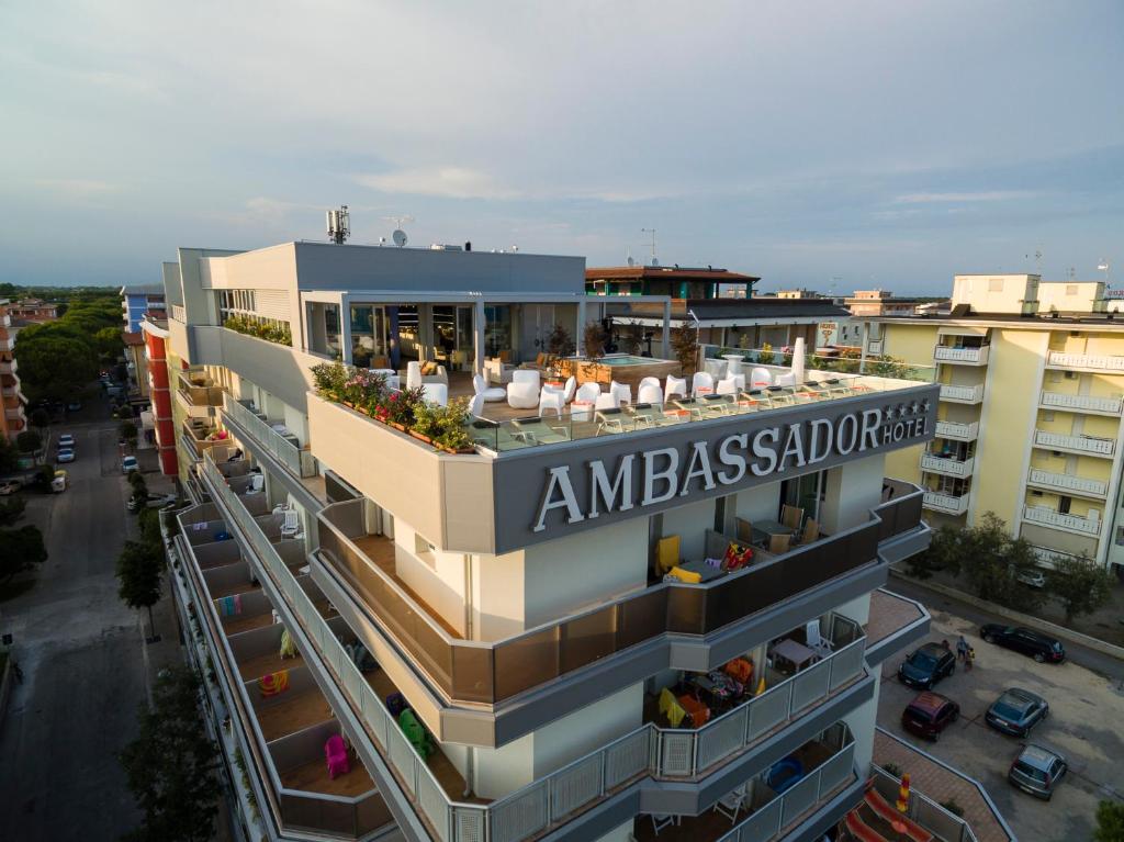 an apartment building with a sign on the top of it at Hotel Ambassador in Bibione