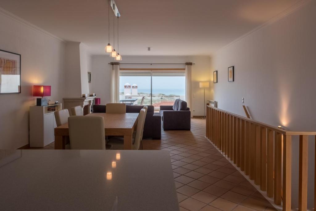 een woonkamer met een tafel en stoelen bij Maravilhoso T2 Vila da Praia in Amoreira