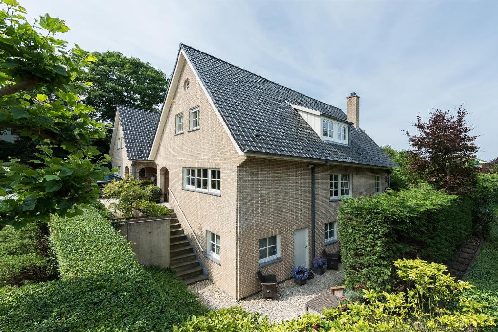 une grande maison en briques avec un toit noir dans l'établissement Parc House Zandvoort, à Zandvoort
