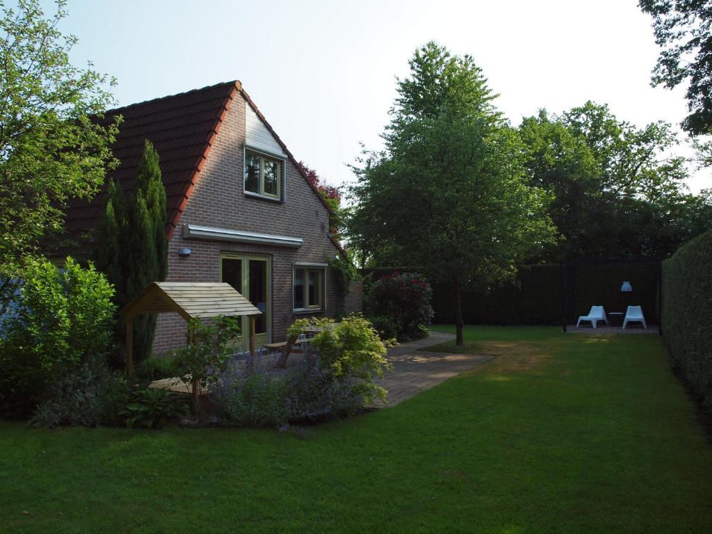 una casa con jardín y 2 sillas en el patio en EnjoyDeVeluwe, en Nunspeet