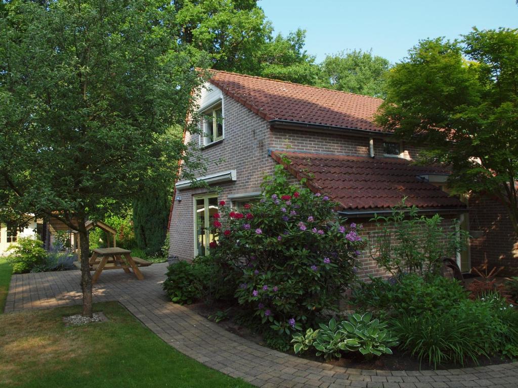 een stenen huis met een bank in de tuin bij EnjoyDeVeluwe in Nunspeet