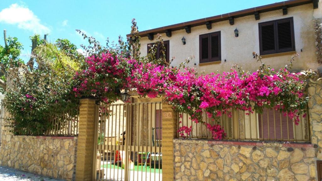 een hek met roze bloemen op een gebouw bij Casa Vacanze Mediterraneo in Tre Fontane