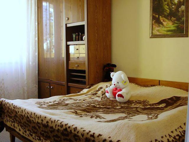 a teddy bear sitting on top of a bed at Роза in Lazarevskoye