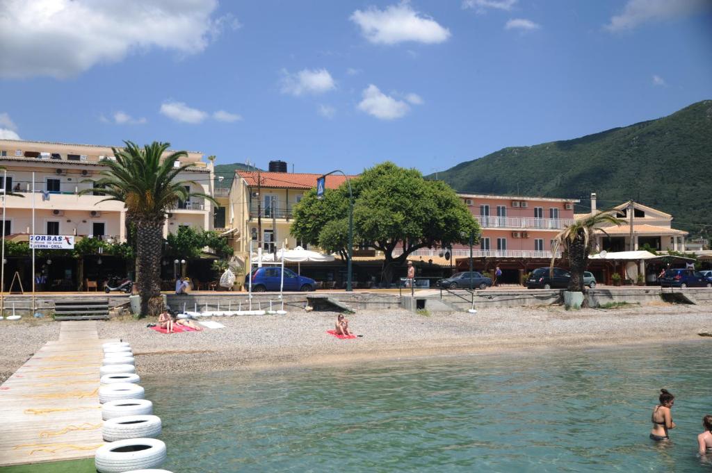 een strand met mensen in het water en gebouwen bij Costa Hotel in Ýpsos