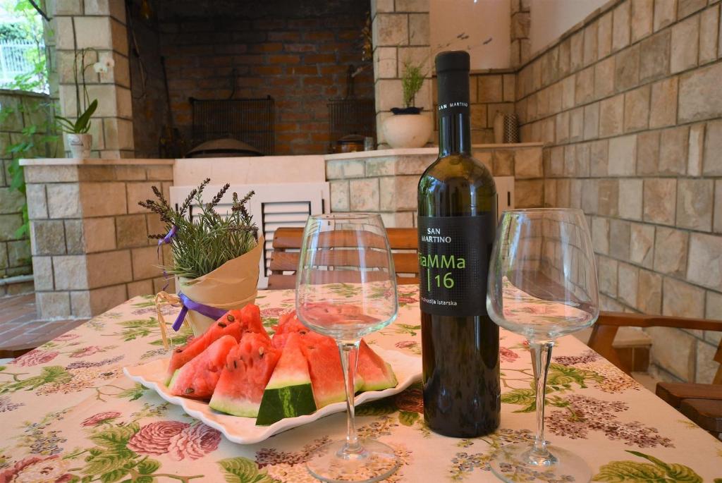 una bottiglia di vino e due bicchieri di vino su un tavolo di Apartman Taraca Villa Knezevic a Herceg-Novi