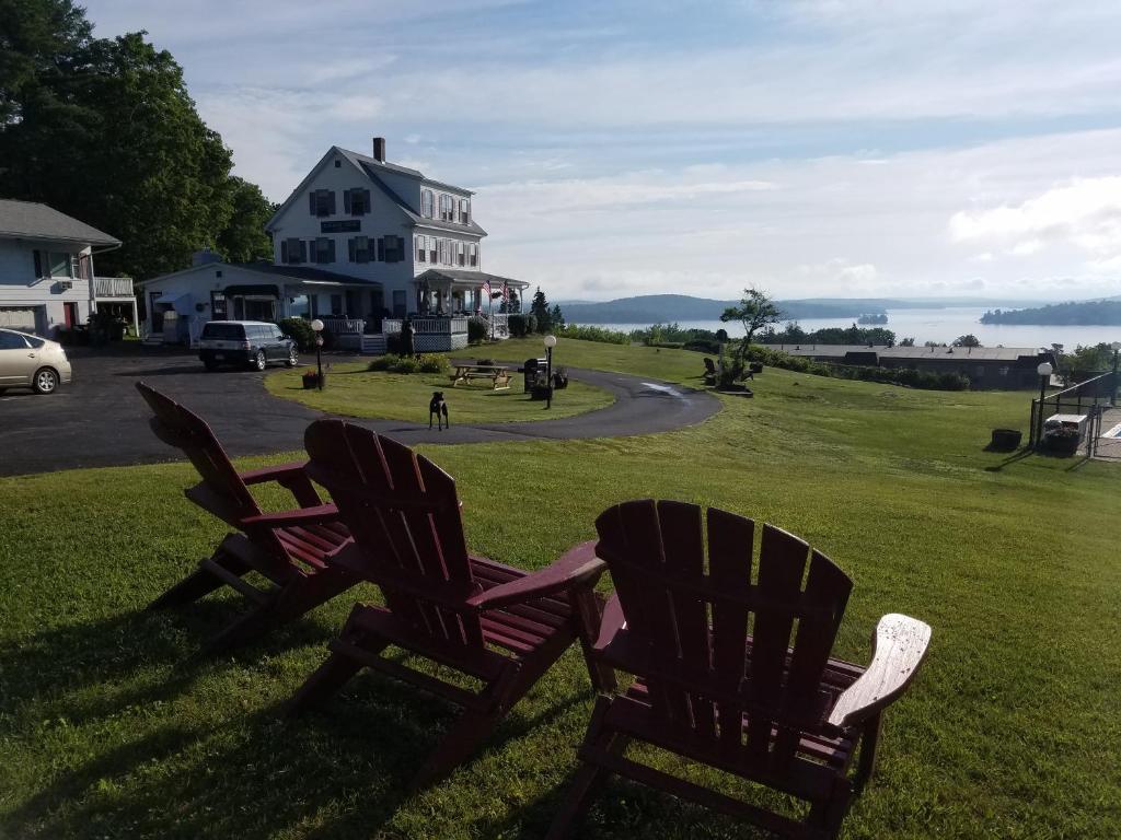 duas cadeiras sentadas na relva em frente a uma casa em Grand View Resort em Weirs Beach