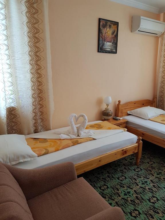 a hotel room with two beds and a couch at Guest Rooms Denitsa in Obzor