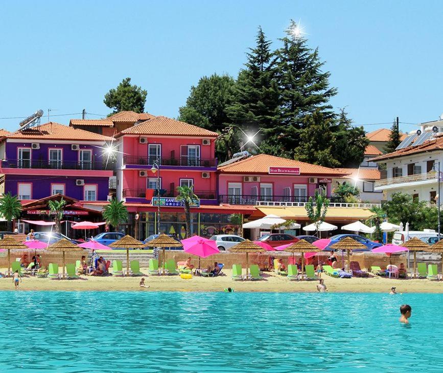 - une plage avec des parasols et des personnes dans l'eau dans l'établissement Star Beach Resort, à Makrigialos