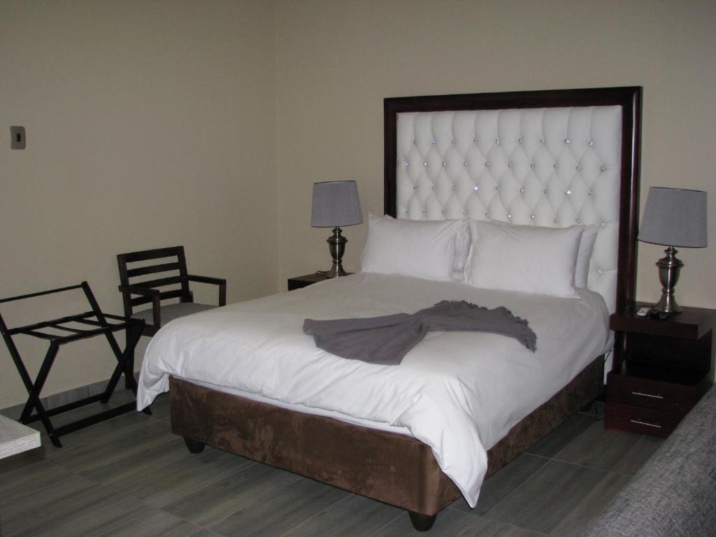 um quarto com uma cama grande e 2 cadeiras em 4 Seam Guest House em Delmas