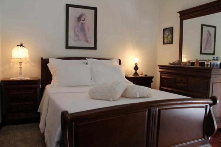een slaapkamer met een groot bed met witte lakens en kussens bij Apartamento Avenida in Ponte de Lima