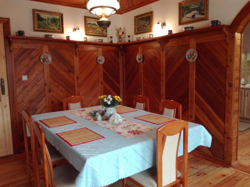 a dining room with a table with a vase of flowers on it at Apartments in Villa Barbara in Świeradów-Zdrój